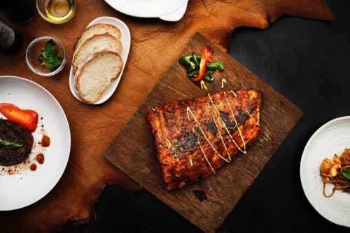 flat lay photography of grilled meat on brown chopping board